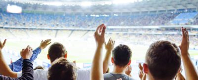Image of fans cheering in a large stadium.